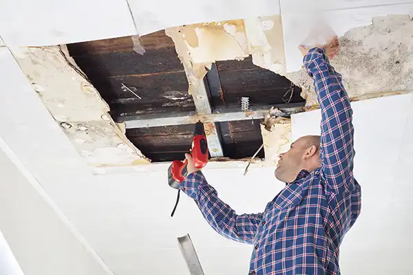 Man repairing mold damage in home ceiling - BCC Restoration in Vancouver WA