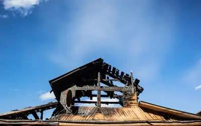 burnt out portland home with blue sky background before fire damage restoration services by BCC
