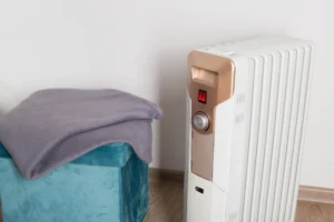An electric heater on a white background next to a warm blanket, a fire safety hazard
